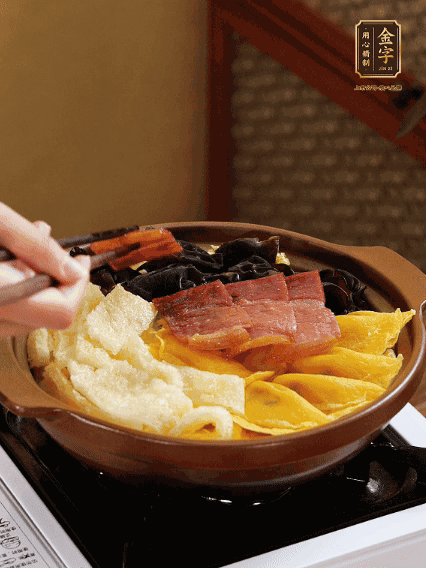 砂锅底部铺上娃娃菜，依次摆上肉皮、蛋饺、黑木耳、火腿